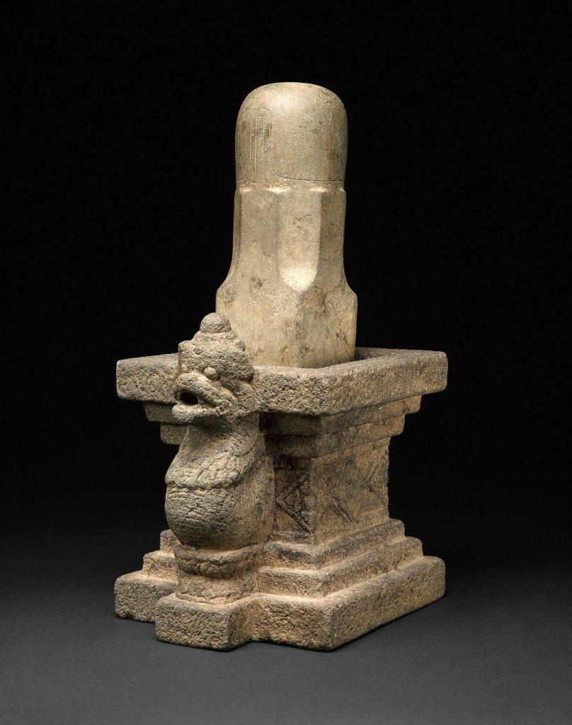 Sculptural stone Shiva Lingam form with base and guardian motif